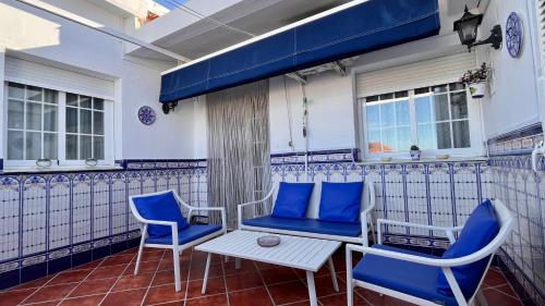 a patio with blue chairs and a table at Apartamento Turístico Casa Bari in Olivenza