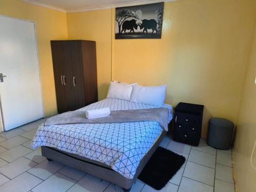 a bedroom with a bed and a cabinet in it at 48 ON Lindi in Welkom