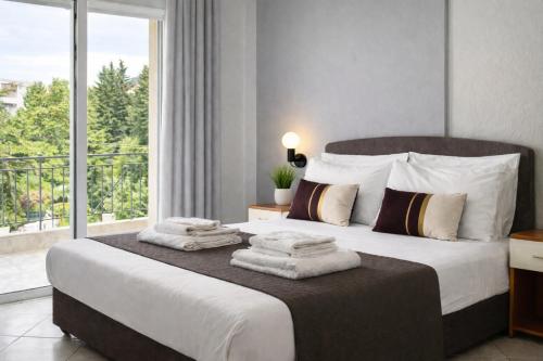 a bedroom with a large bed with towels on it at DOMES APARTMENTS in Kallithea Halkidikis