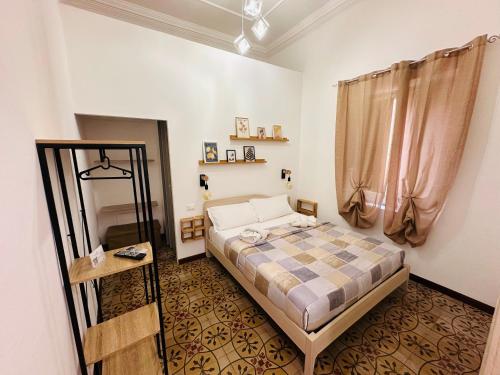 a small bedroom with a bed and a window at Calvino Home in Trapani