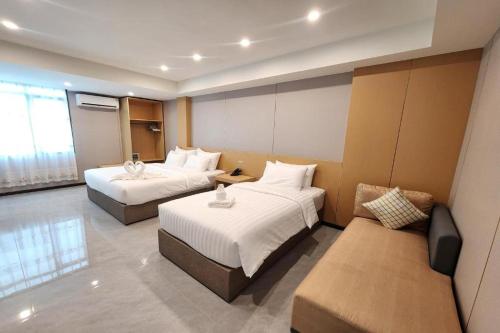 a hotel room with two beds and a couch at VELIN Pattaya Hotel-Central Pattaya-3 in Pattaya