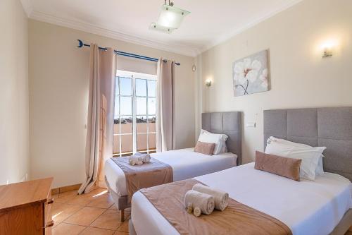 a hotel room with two beds and a window at Villa Tulipa by Algarve Holidays in Albufeira