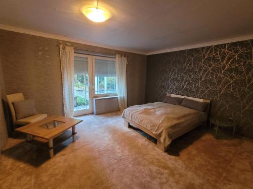a bedroom with a bed and a table and a chair at Haus Sonnengarten in Brokstedt