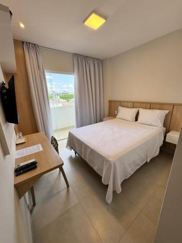 ein Schlafzimmer mit Bett, Schreibtisch und Fenster in der Unterkunft Hotel Sierra in Cuité