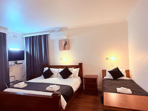 a hotel room with two beds and a television at Coonalpyn Hotel in Coonalpyn