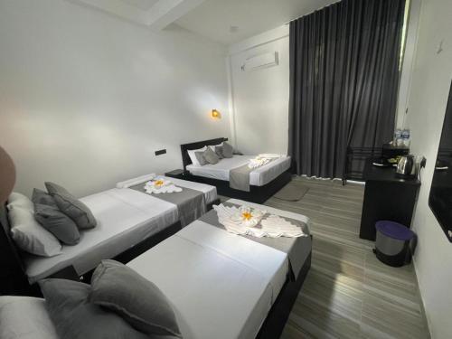 a hotel room with two beds and a balcony at Sinharaja Eliphinity Hotel and Restaurant in Deniyaya