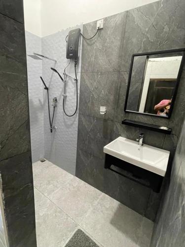a bathroom with a sink and a mirror and a shower at Sinharaja Eliphinity Hotel and Restaurant in Deniyaya