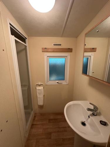 a bathroom with a sink and a mirror and a window at Serenity Beach Pinar in Chipiona