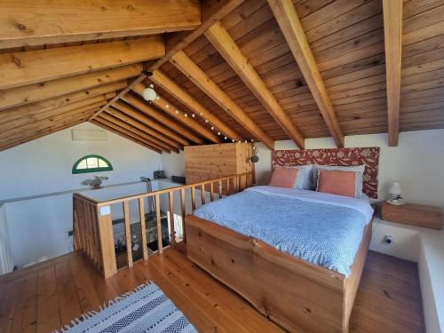 a bedroom with a bed in a room with wooden ceilings at Sunset Nest in Ponta Delgada
