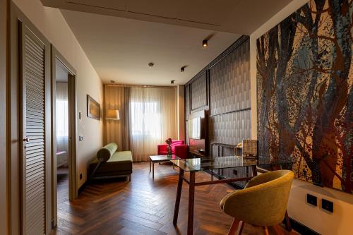 a living room with a glass table and chairs at Vértice Sevilla Aljarafe in Bormujos