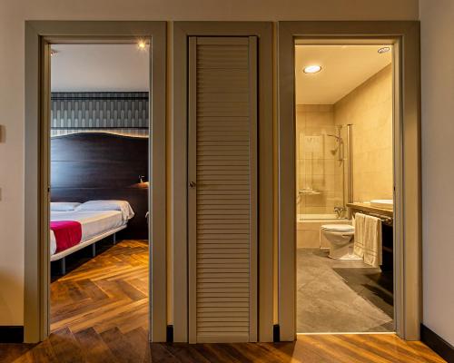 a hotel room with a bed and a bathroom at Vértice Sevilla Aljarafe in Bormujos