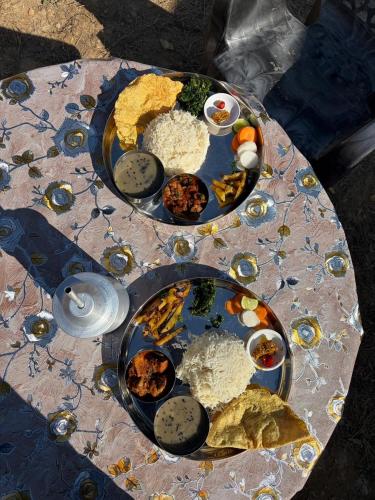 a table with two plates of food on it at Bagchandi resort in Kathmandu
