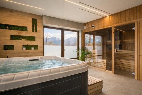 a large bathroom with a soaking tub and a large window at Dworek pod Giewontem - Jacuzzi & Sauna in Kościelisko