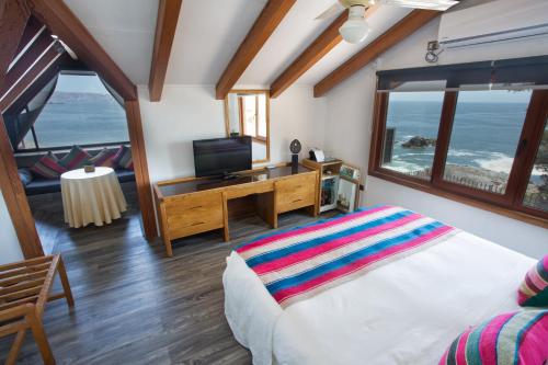 um quarto com uma cama, uma televisão e uma varanda em Hotel Oceanic em Viña del Mar
