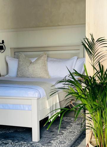 a white bed in a room with two plants at 15 On Candy in Midrand