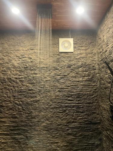 a shower in a room with a ceiling with lights at Tetebatu Valley Bungalows in Tetebatu
