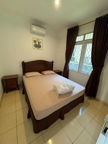 a bedroom with a bed in a room with a window at Lamar Villas 2 in Tengahgirang