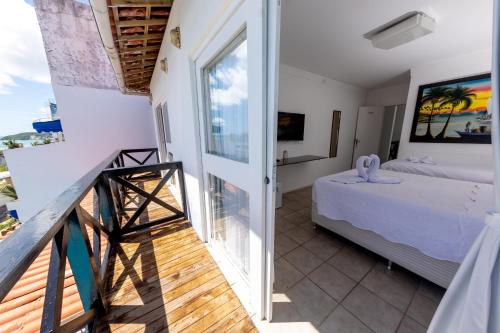 a bedroom with a bed and a balcony at Breeze Hotel in Natal