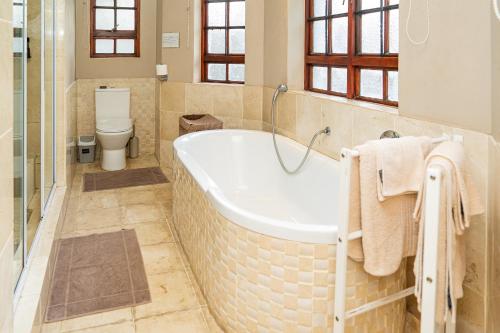 a bathroom with a bath tub and a toilet at Cu Guest House in Phalaborwa