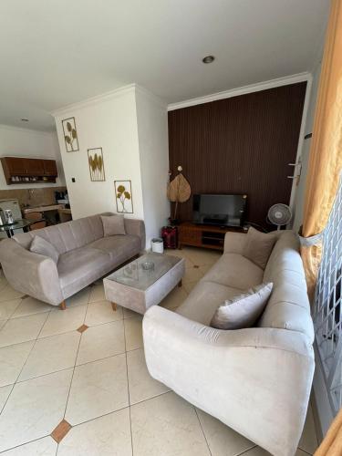 a living room with two couches and a tv at Lamar Villas 2 in Tengahgirang