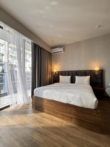a bedroom with a large bed and a large window at Solis apart otel in Batumi