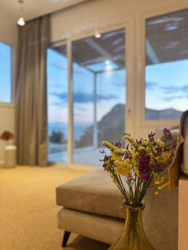 a vase filled with flowers on a table in a living room at Almyra Suites in Archangelos