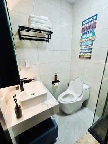 a bathroom with a white toilet and a sink at Platinum apartments in Gaborone