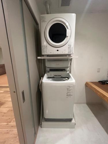 a microwave sitting on top of a washer and dryer at 蘇生の宿Samsara Inn - 1日1組の特別な宿 - in Tanabe