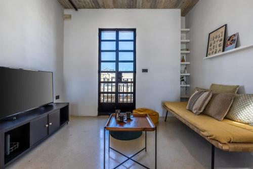 a living room with a couch and a tv at Birkirkara Typical 2BDR Townhouse in Birkirkara