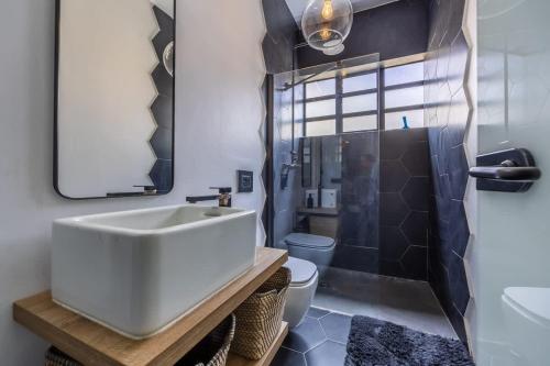 a bathroom with a sink and a shower and a toilet at Birkirkara Typical 2BDR Townhouse in Birkirkara