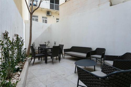a patio with tables and chairs in a courtyard at Four Bedroom Typical Maltese Townhouse - One Minute Away From The Seafront in Sliema