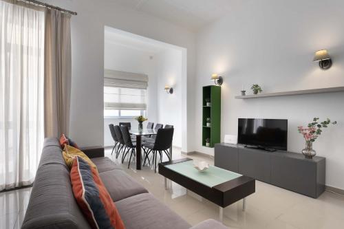 a living room with a couch and a table at Four Bedroom Typical Maltese Townhouse - One Minute Away From The Seafront in Sliema