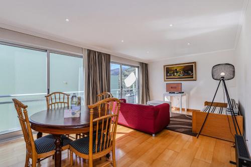 a living room with a table and a red couch at GuestReady - Santo Amaro apartment in Vila Franca do Campo