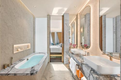 ein Badezimmer mit zwei Waschbecken und einer Badewanne in der Unterkunft Mandarin Oriental Downtown, Dubai in Dubai