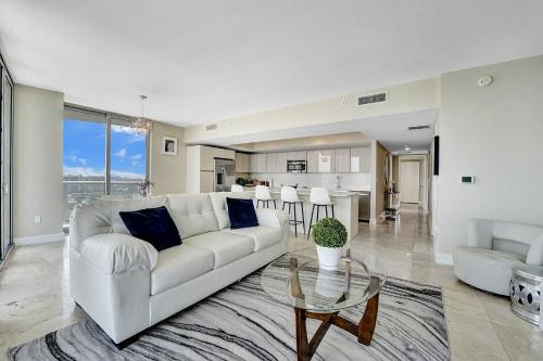 a living room with a white couch and a table at Beachwalk Resort in Hallandale Beach