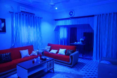 a living room with two red couches and a table at Villa Sahel in Niamey