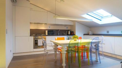 a kitchen with a table with colorful chairs in it at Loft Della Baia a Due Passi dal Mare in Sestri Levante