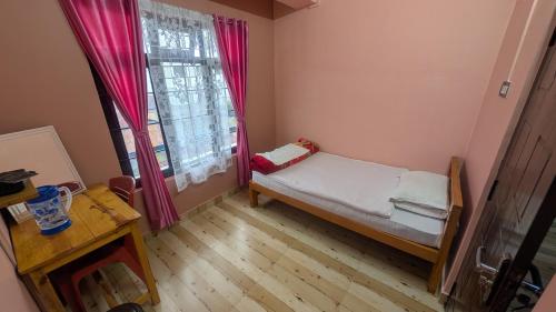 a small room with a bed and a window at Mebaker View Inn in Shillong