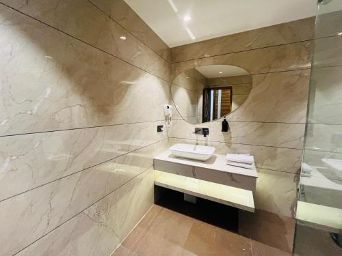 a bathroom with a sink and a mirror at Red Leaf Hisar in Hisār
