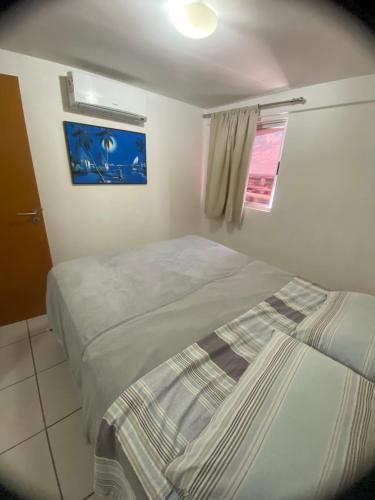 a bedroom with two beds and a window at Apartamento 2 quartos West Flat in Mossoró