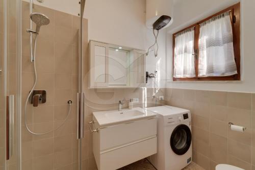 a bathroom with a washing machine and a sink at Casa Marida tra Cotoncello e Sant'Andrea - Goelba in SantʼAndrea