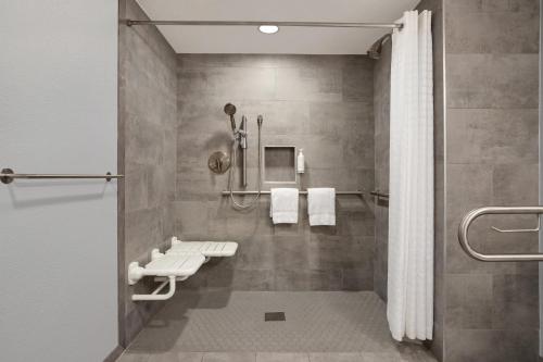a bathroom with a shower and a toilet in it at Home Inn & Suites in Orlando