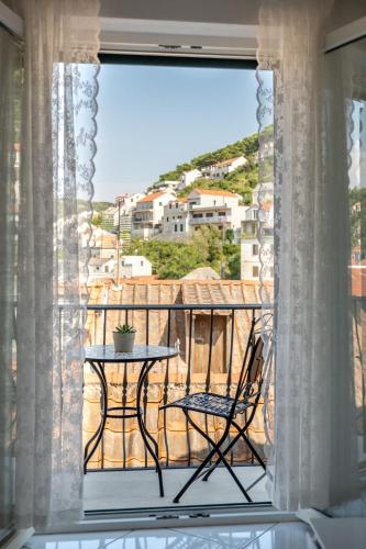 a table and chair on a balcony with a view at Apartments Sonja in Pučišća
