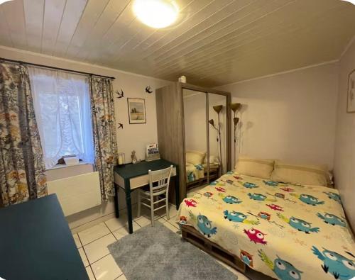 una camera da letto con un letto e una scrivania di Bienvenue a Saint-Dalmas-le-Selvage