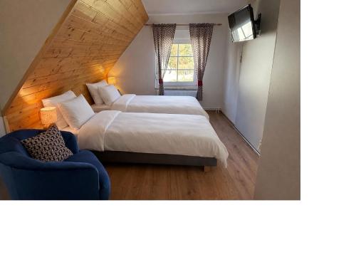 a bedroom with two beds and a blue couch at Ferienzimmer Präkel in Kloster
