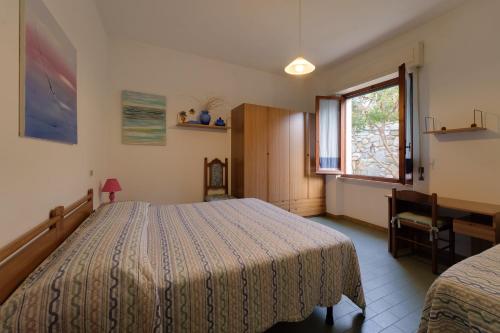 a bedroom with a bed and a window at Appartamento Pomonte la Posta - Goelba in Pomonte
