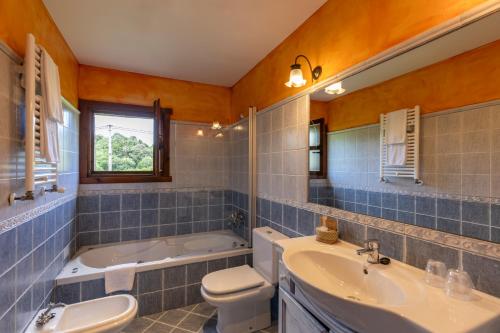 a bathroom with a sink and a toilet and a tub at Hotel La Lluriga in La Galguera