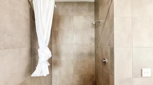 a shower with a white shower curtain in a bathroom at Westbrook 3B3B Home by GoodLive in Truganina