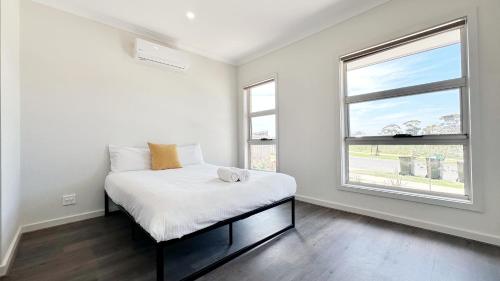a white bedroom with a bed and a window at Westbrook 3B3B Home by GoodLive in Truganina