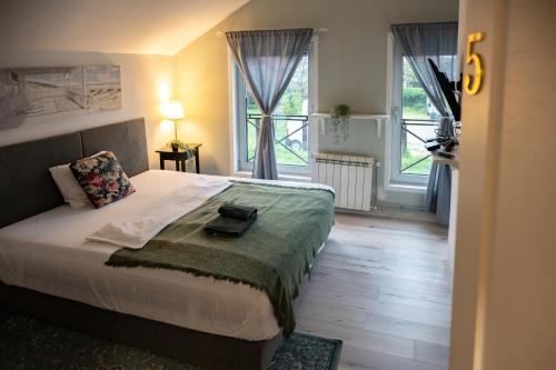 a bedroom with a large bed and two windows at MiniCity Inn in Belgrade